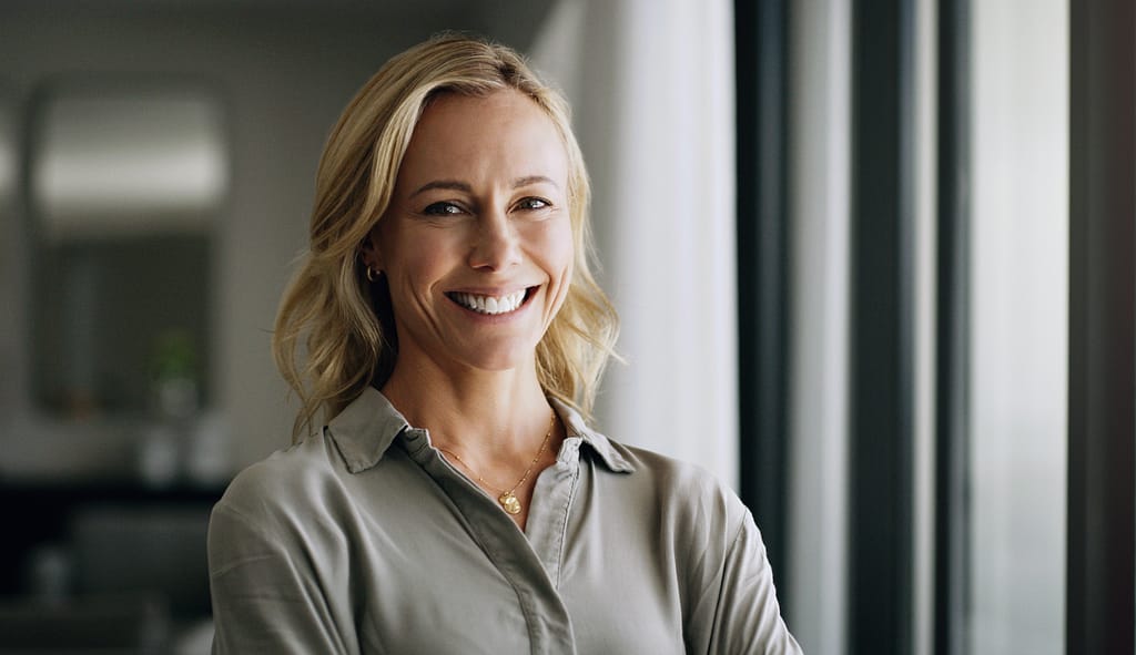 business woman in the office with positive, happy and optimistic mindset. Happiness, smile and professional mature female executive boss standing with confidence in workplace